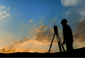 A surveyor looks through his instrument.