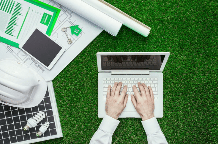 laptop on lawn with tablet and plans