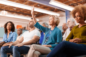 woman with her hand raised at a rezoning community meeting