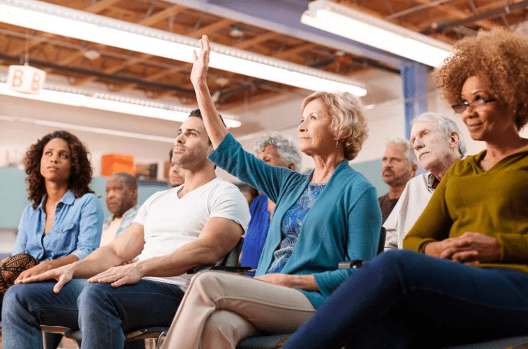 woman with her hand raised at a rezoning community meeting